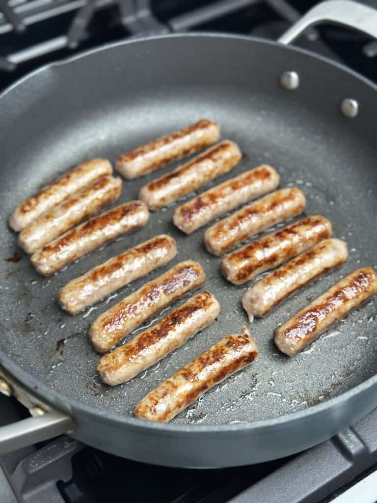 Sausages being cooked in a pan