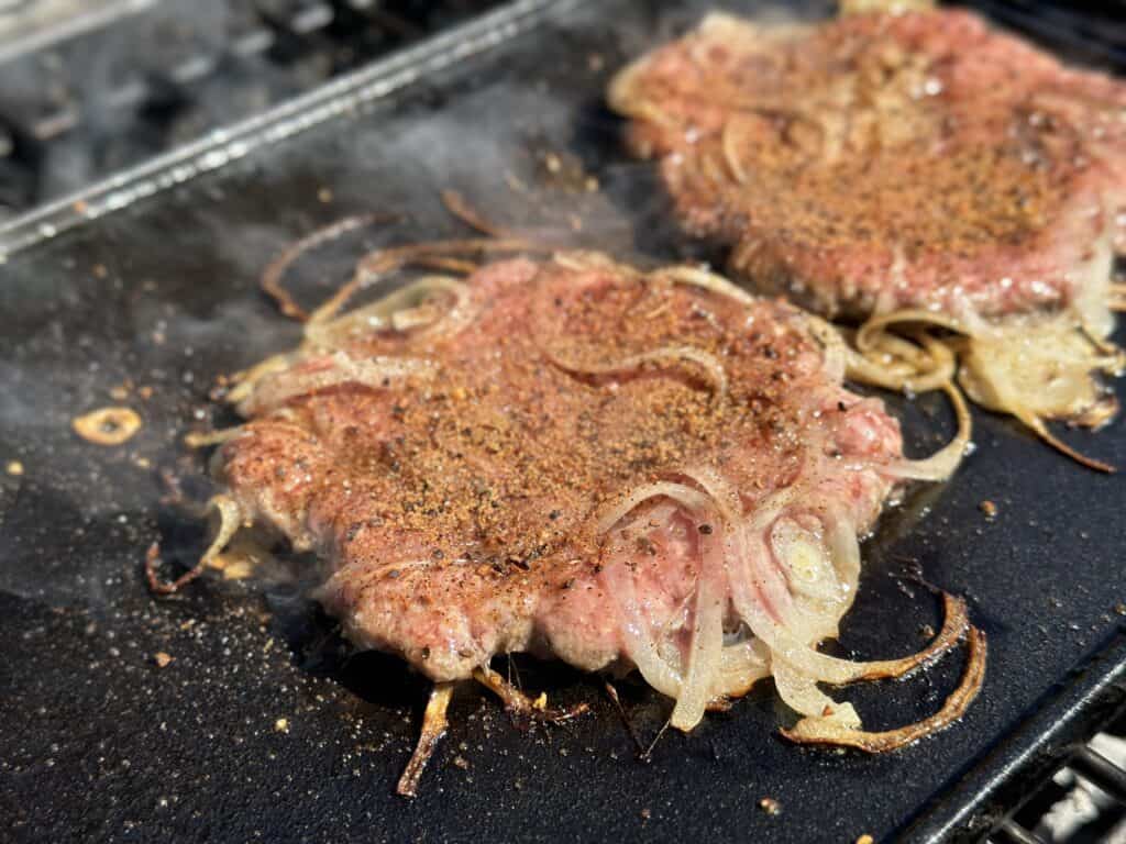 burger being smashed down on cast iron.