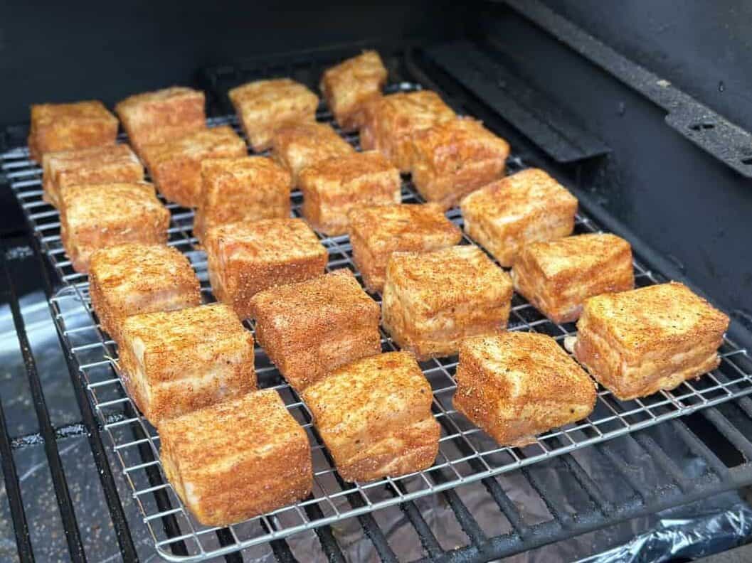 pork belly burnt ends on a wire rack on the smoker.