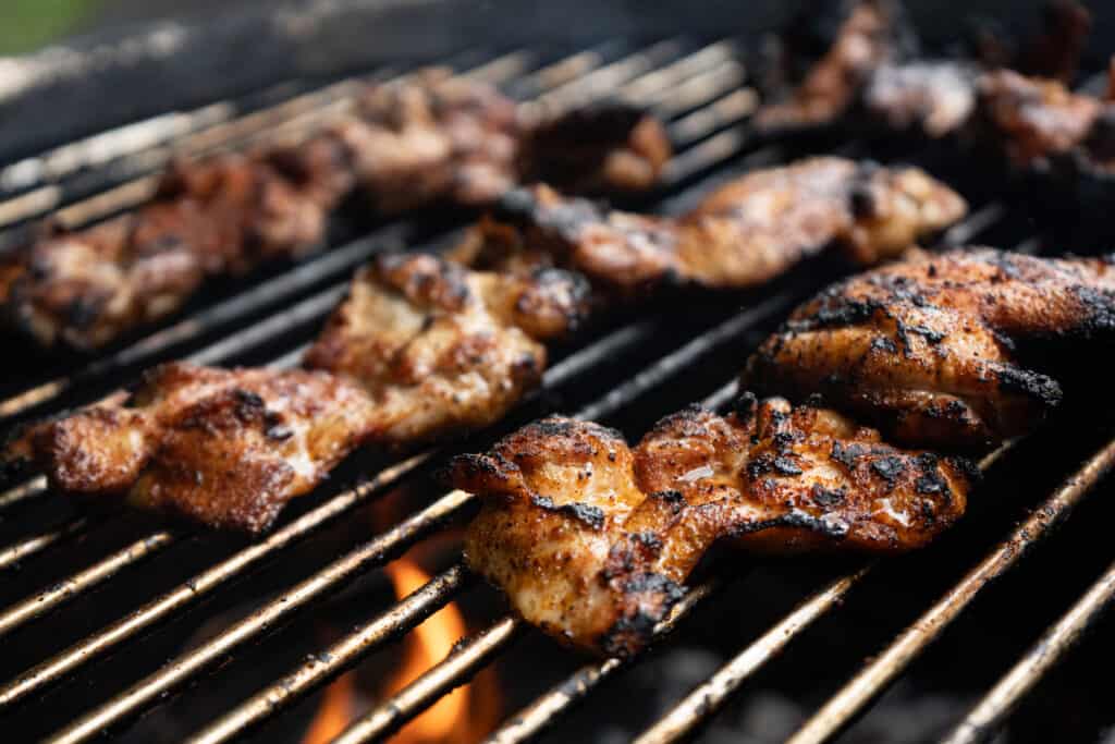 chicken thighs being grilled over chicken