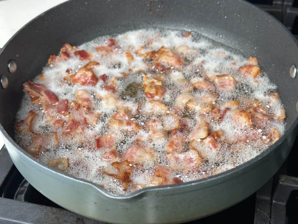 bacon being fried in a pan