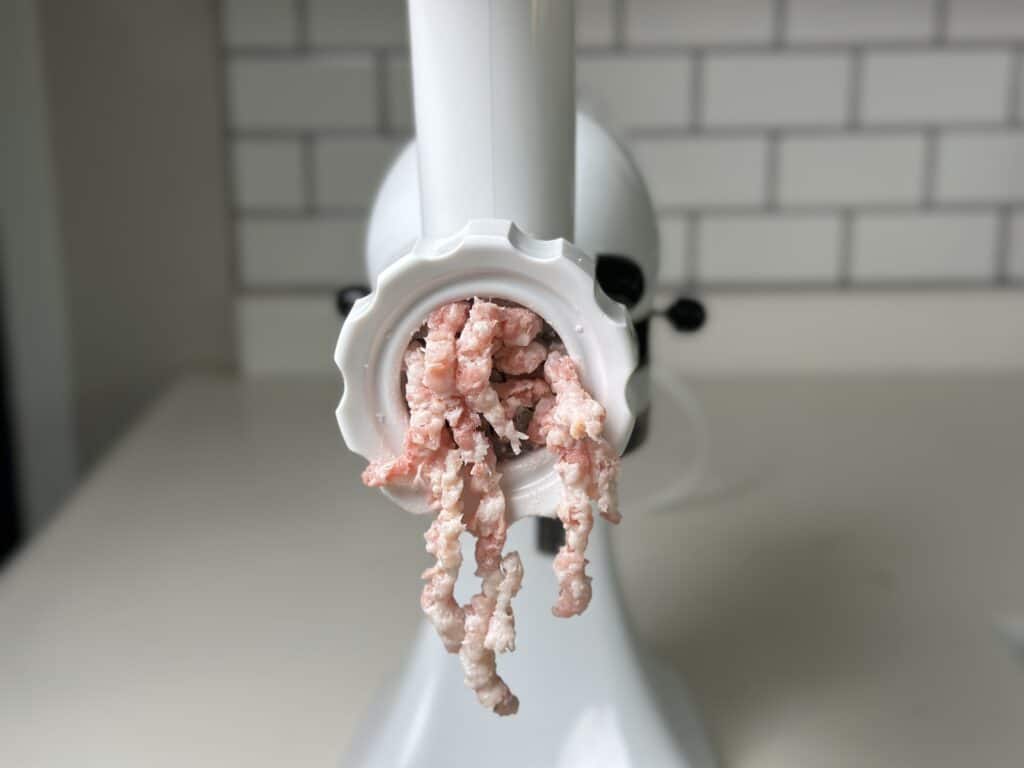 bacon coming out of a grinder