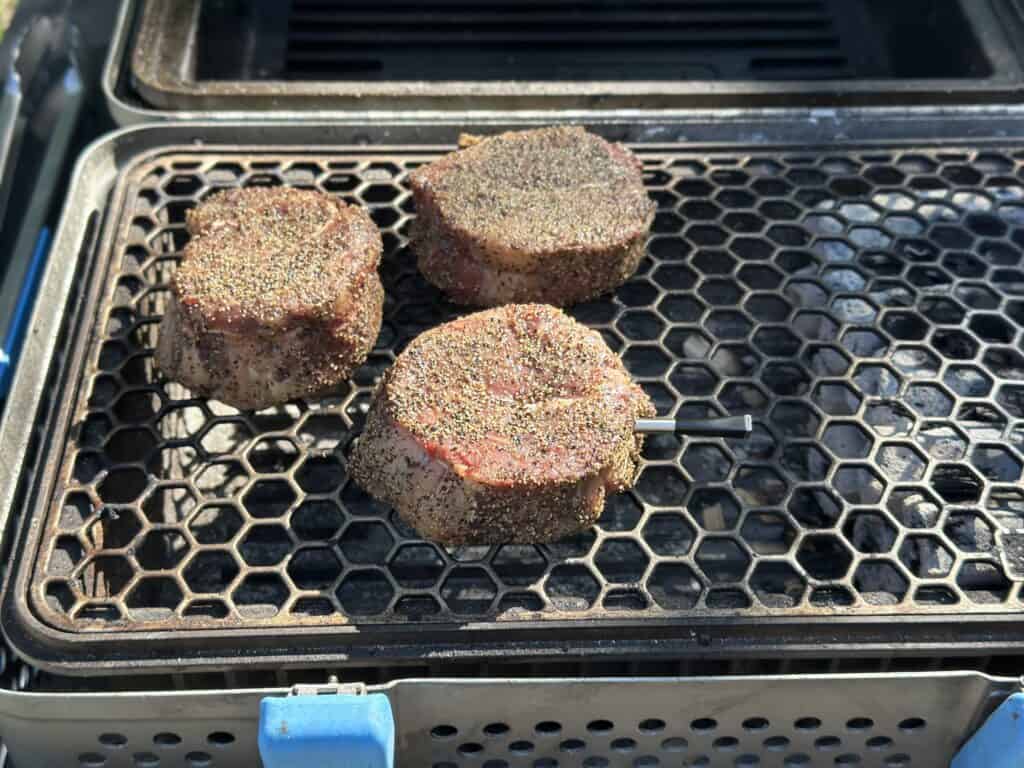 steaks smoking on the grill