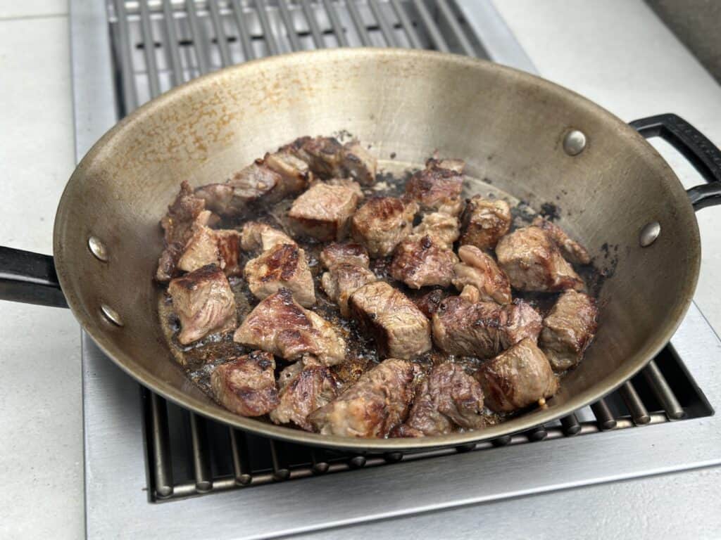 garlic herb butter steak bites cooking in a pan