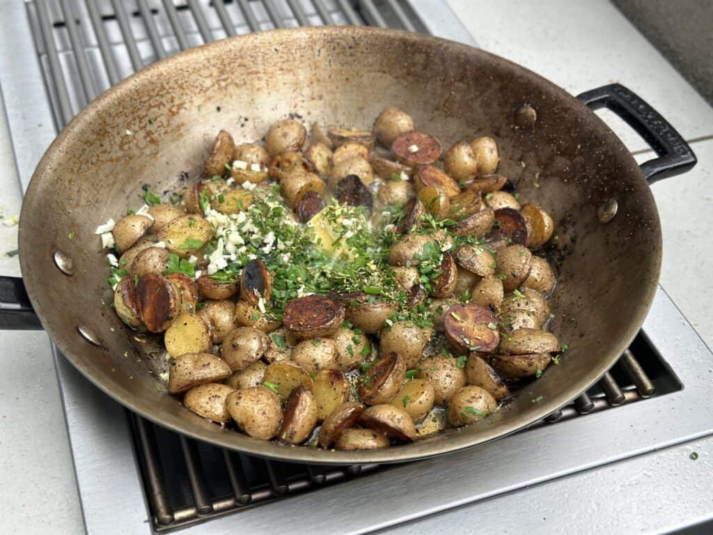 potatoes and herbs cooking in a pan