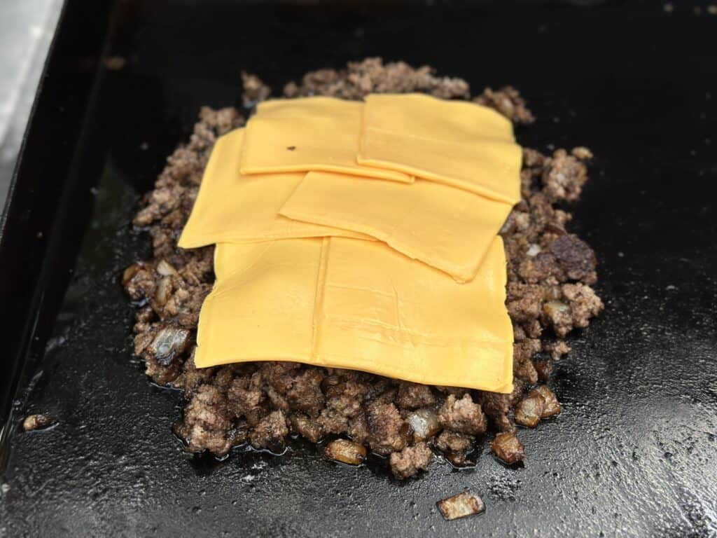 chopped cheese sandwich with American cheese on a griddle