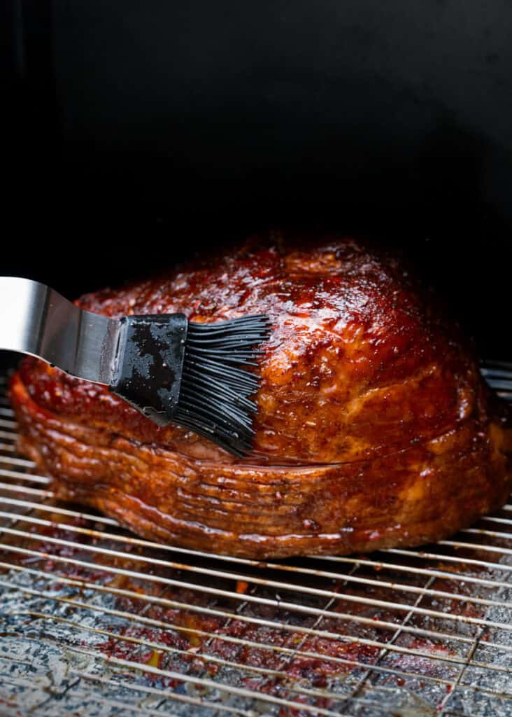 Ham being glazed on the smoker.