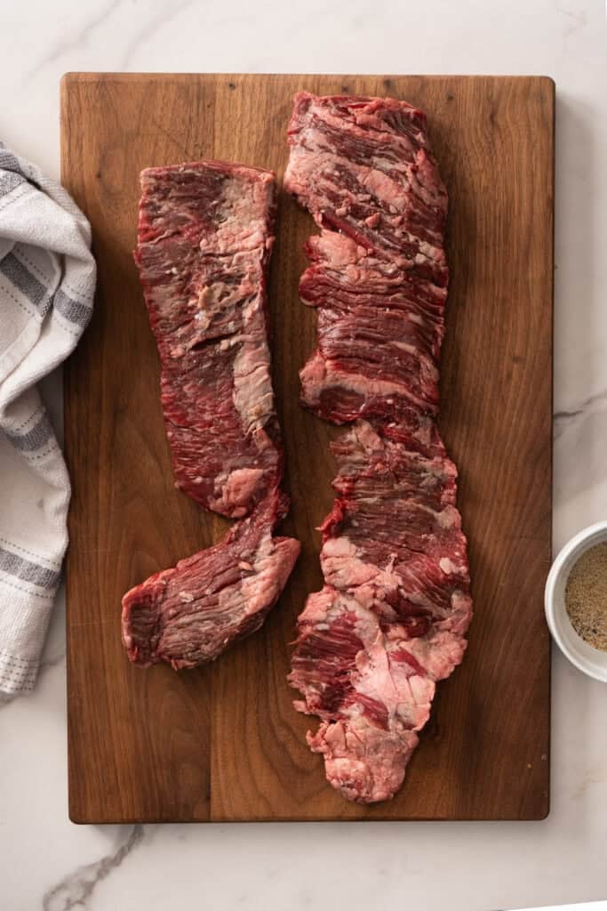 Skirt steak being seasoned.
