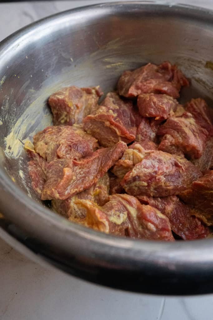 chuck roast burnt ends coated in yellow mustard.