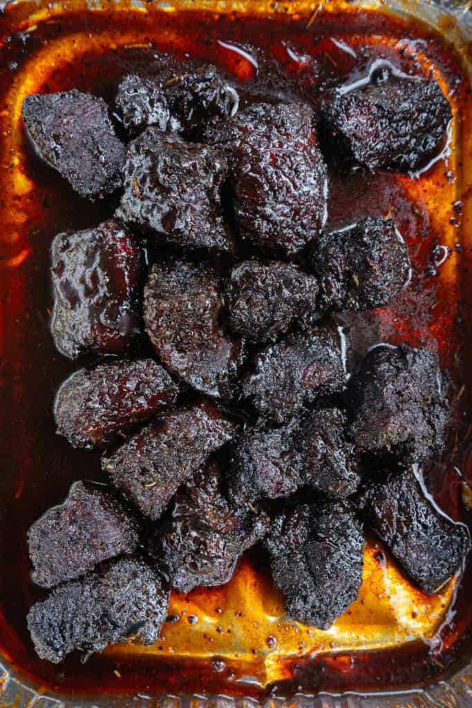 Smoked chuck roast burnt ends in a foil pan.