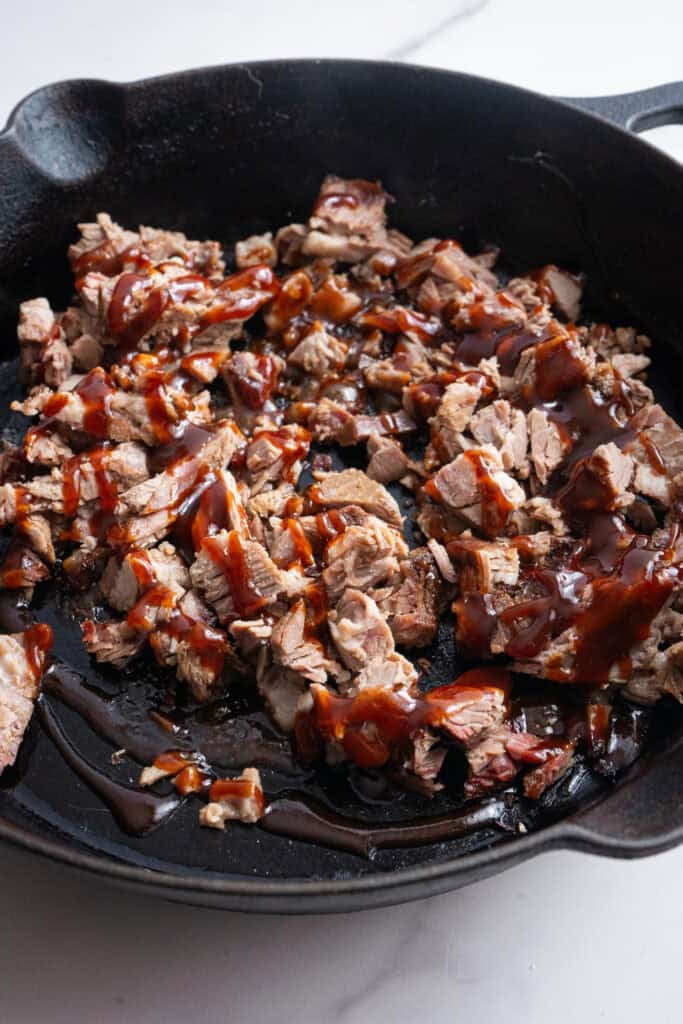 Chopped brisket cooking in a skillet.