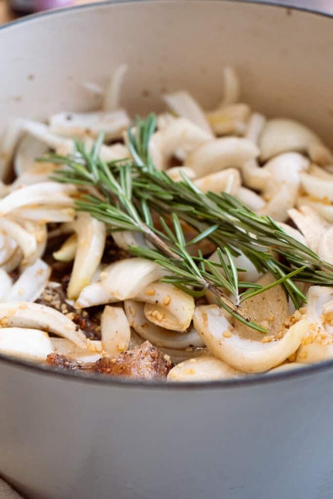 Chuck roast braising in a dutch oven.