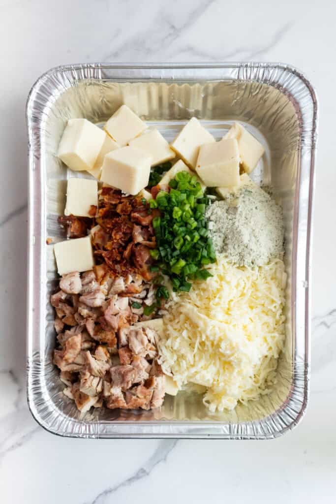Chicken bacon ranch ingredients in a foil pan.