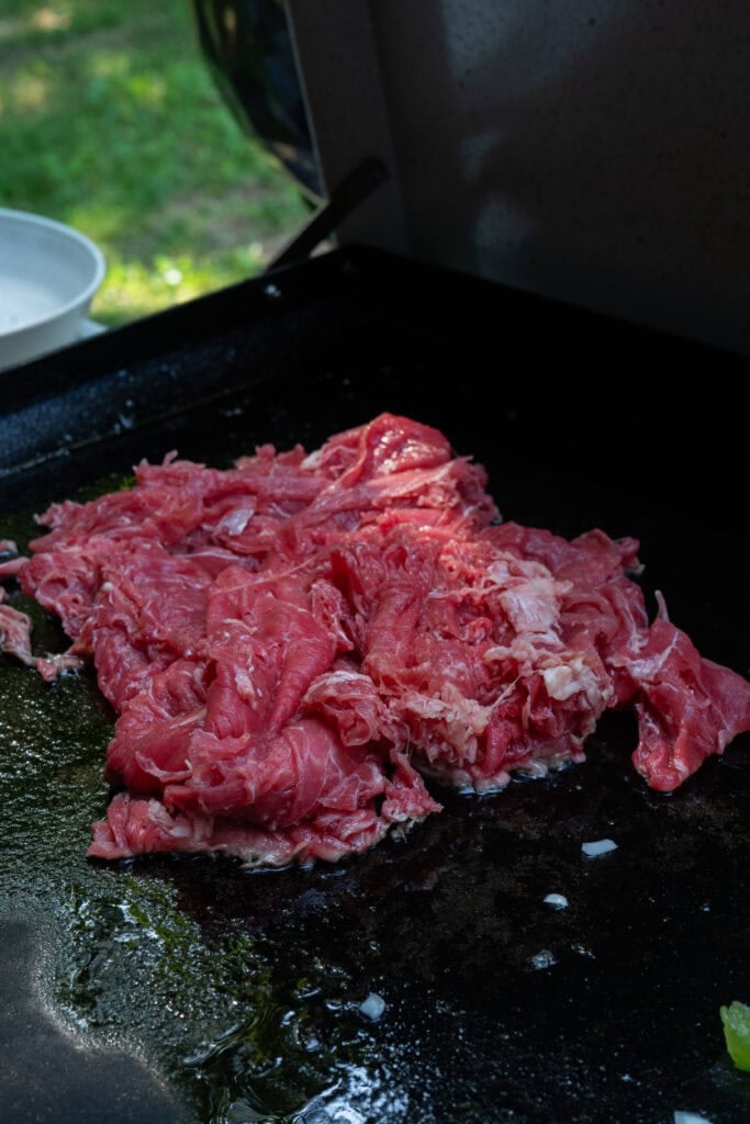 shaved beef cocking on a griddle.