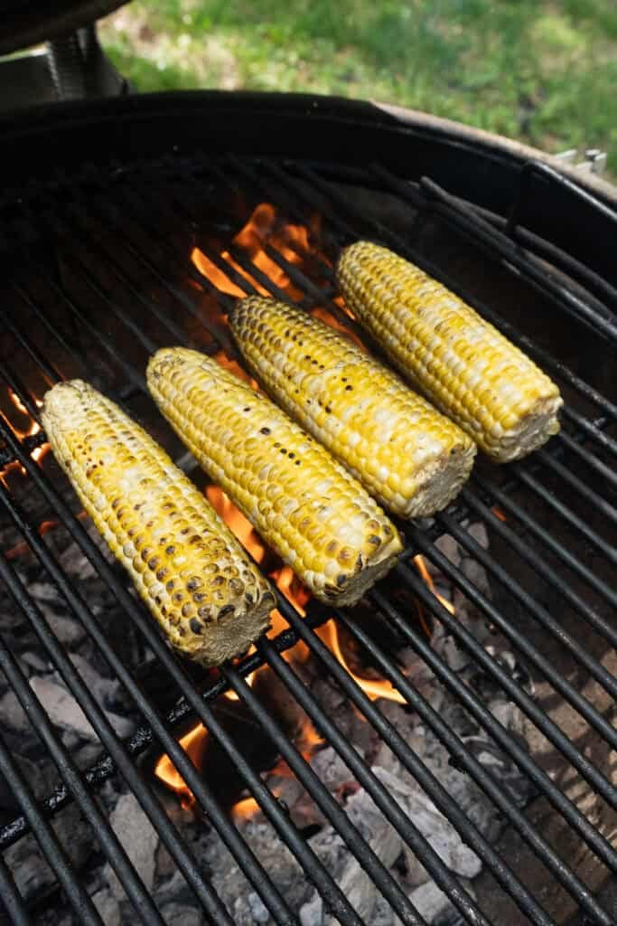 Grilled corn cooking on the grill.
