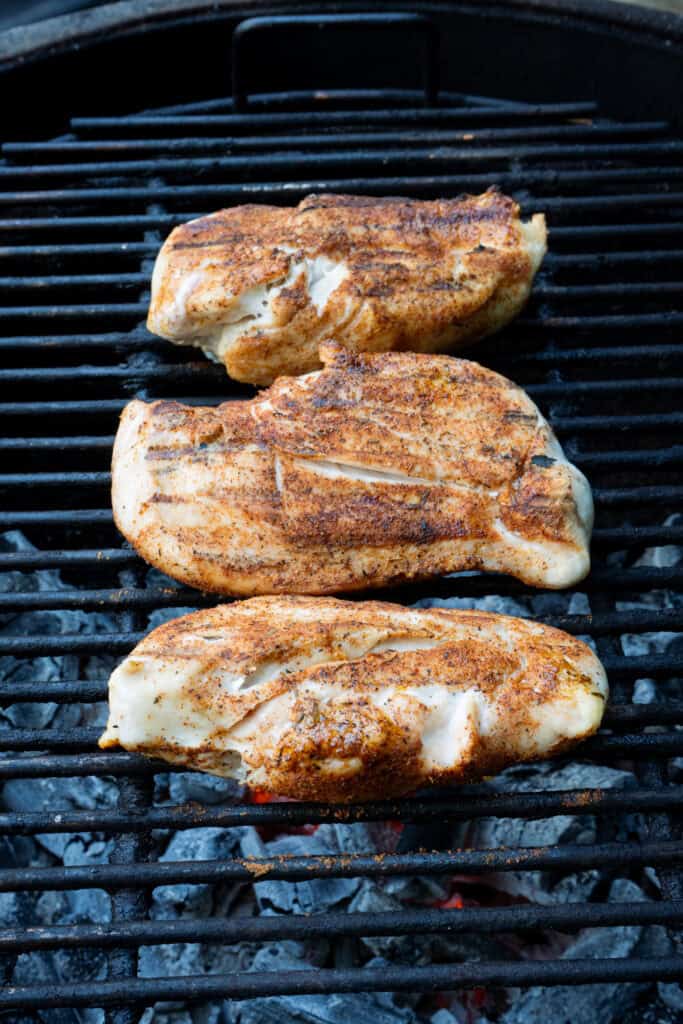 Grilled chicken breast cooking on a grill.