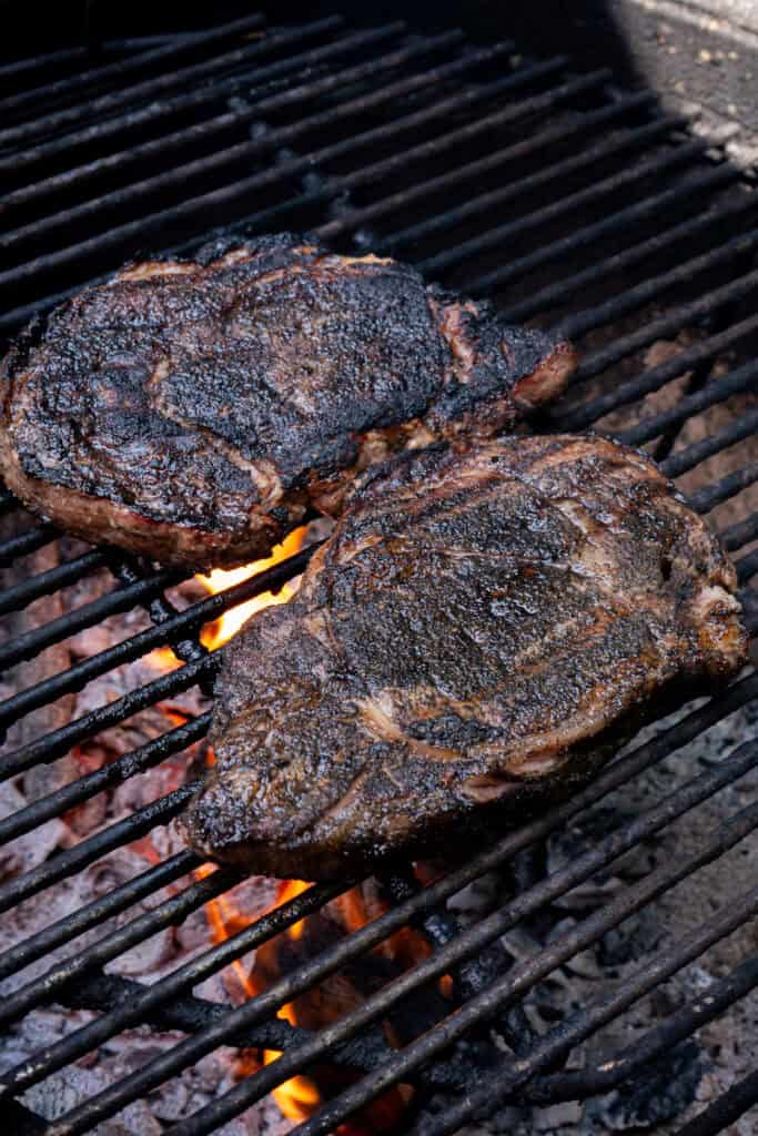 Steaks grilling over direct heat.