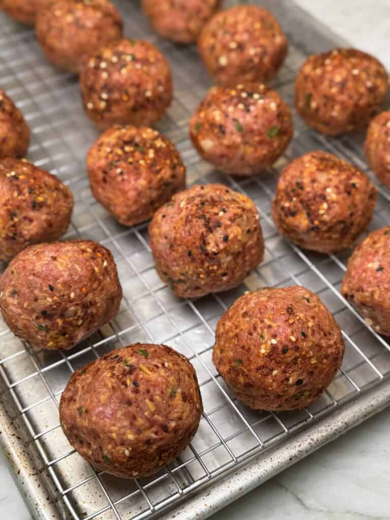 jalapeno popper smoked meatballs on a wire rack.