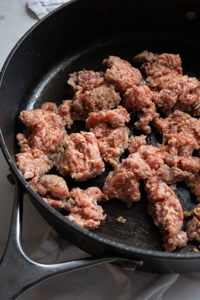 Sausage cooking in a skillet.