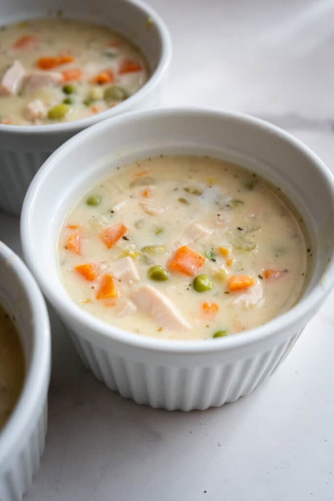 Ramekin filling with turkey pot pie.