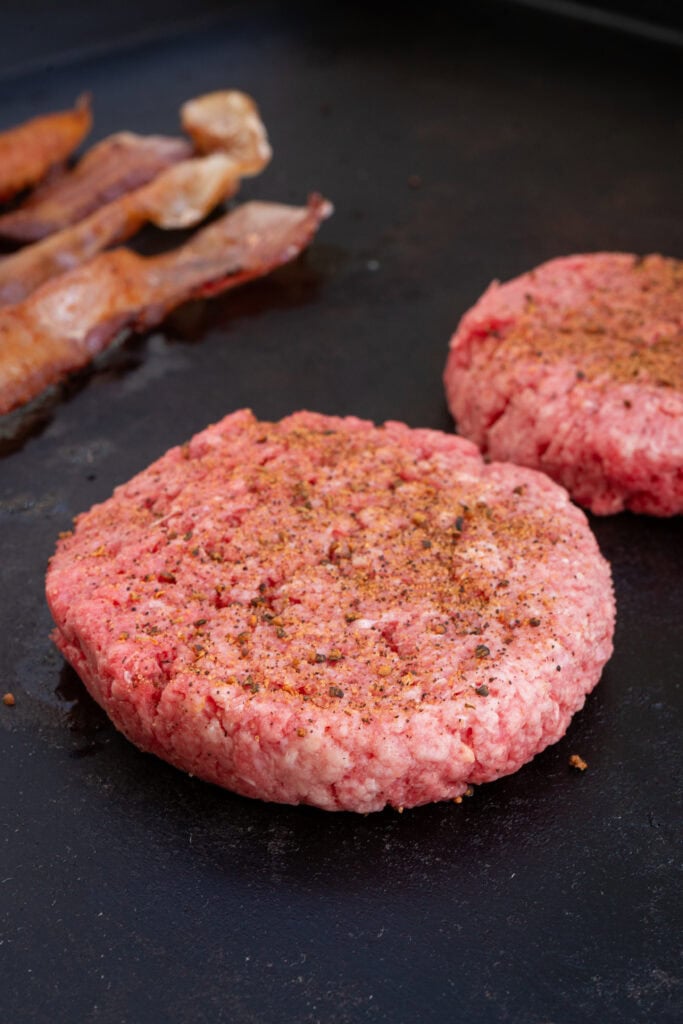 burgers cooking on the griddle.