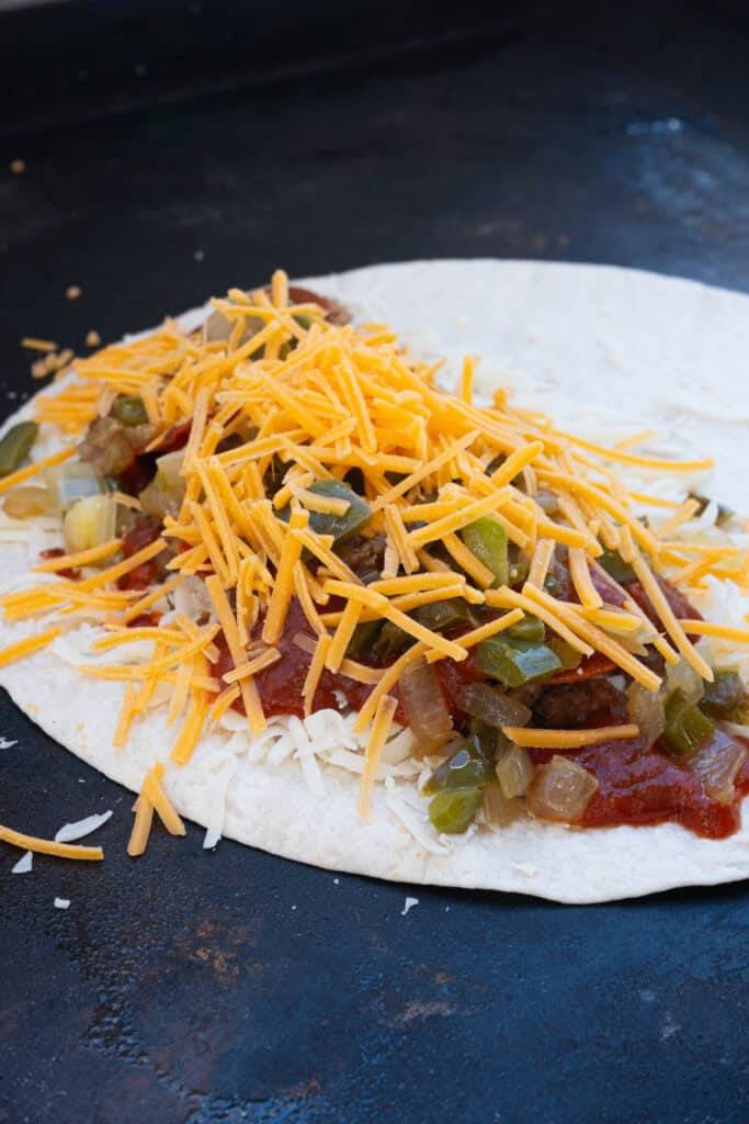 pizza quesadillas cooking on a griddle.