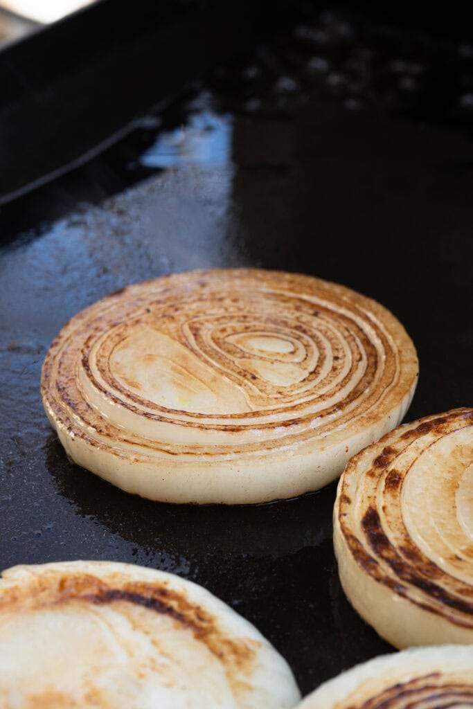 onions cooking on a griddle.