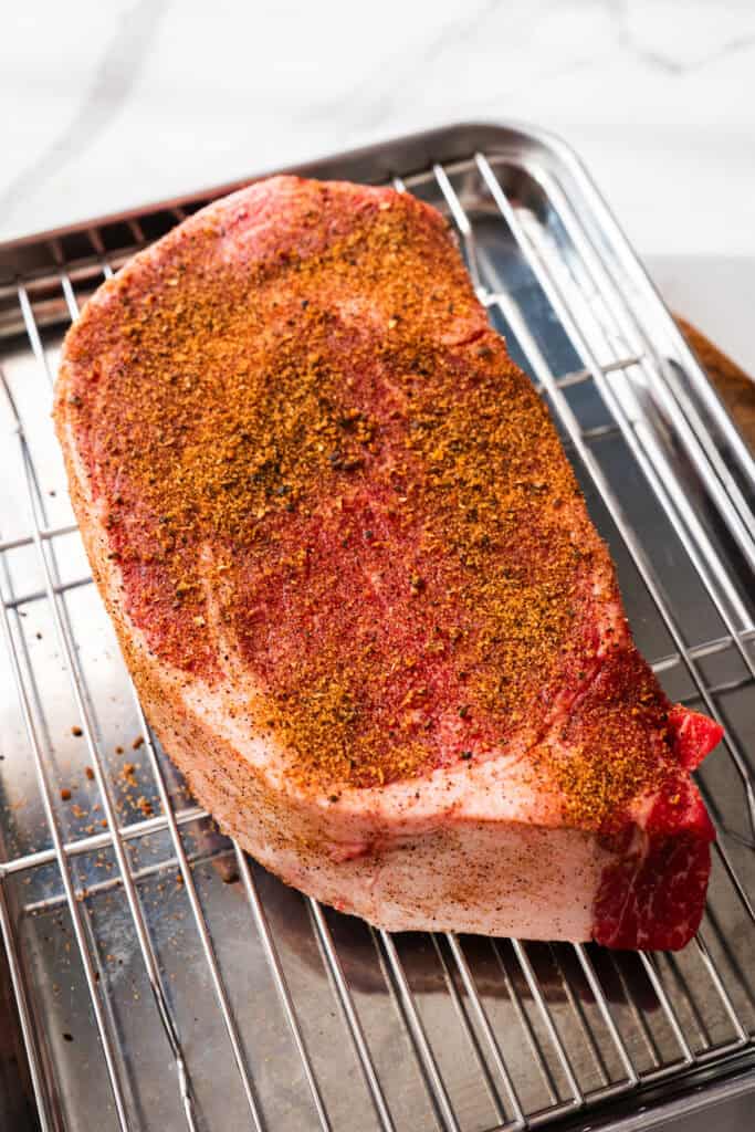 Steak seasoned and sitting at room temperature.