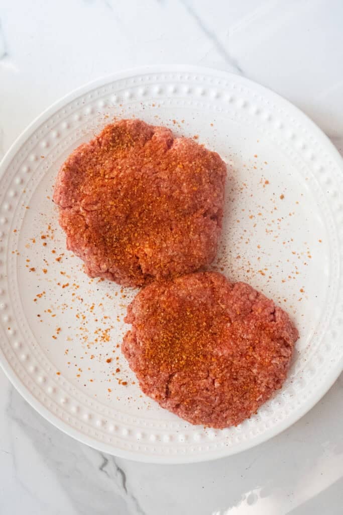 Hamburger patties seasoned.