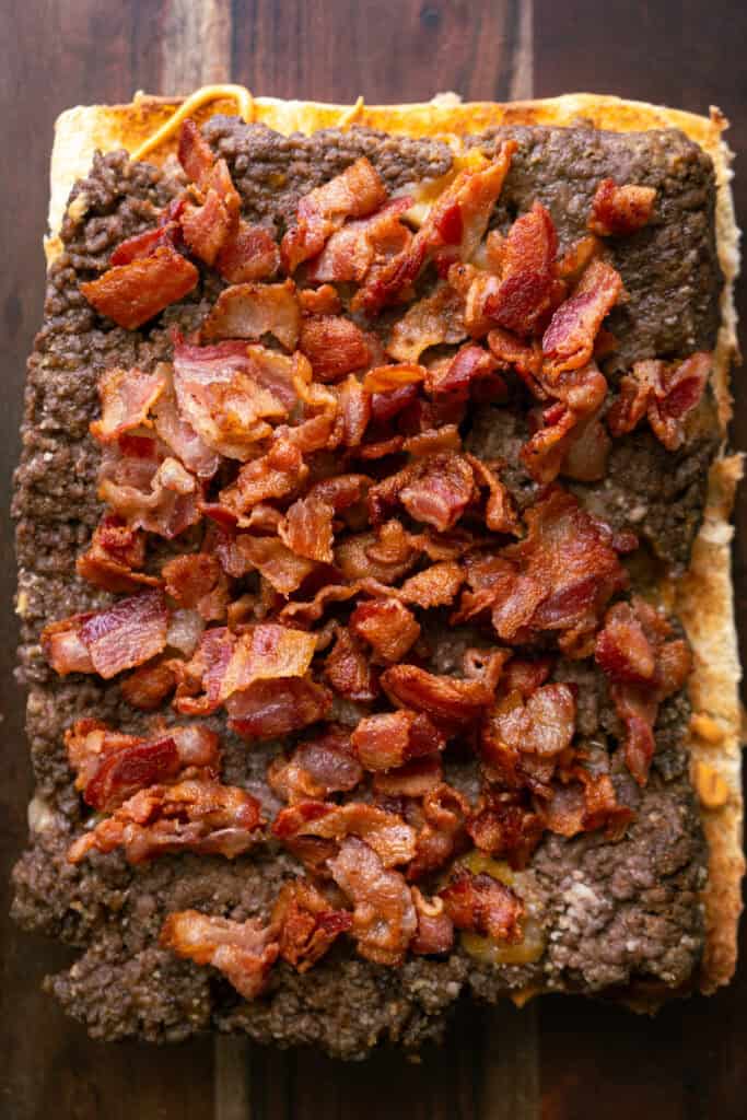 Bacon on burger slab.