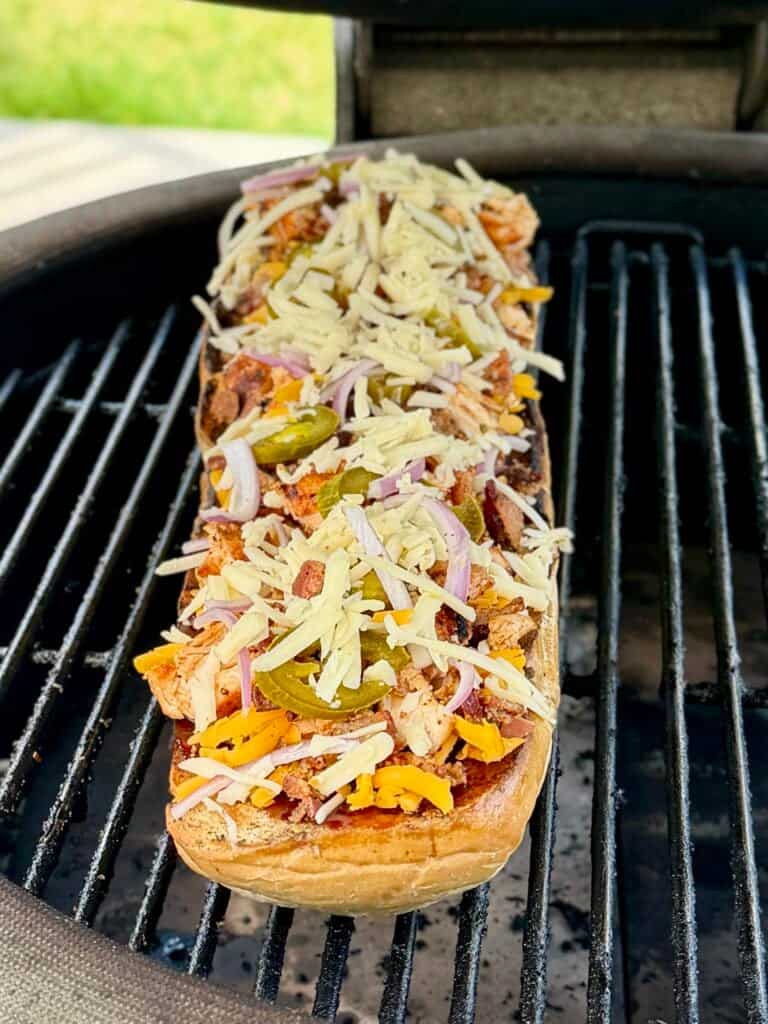 BBQ Chicken French bread pizza being cooked on the grill.