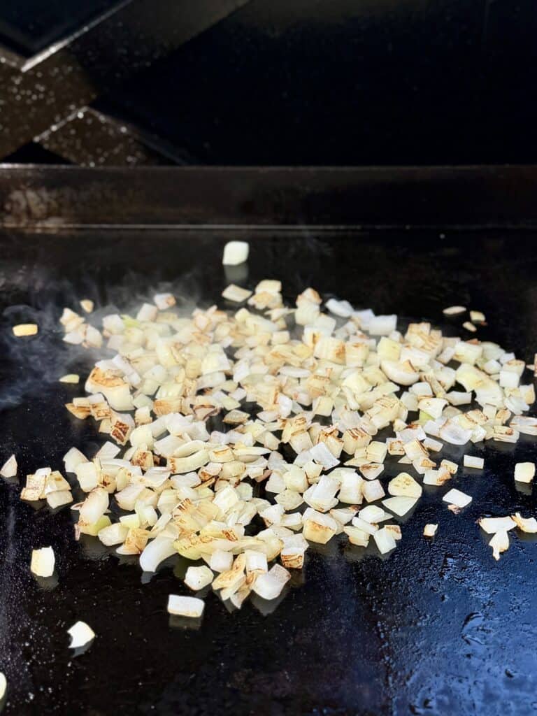 Onions cooking on a griddle.