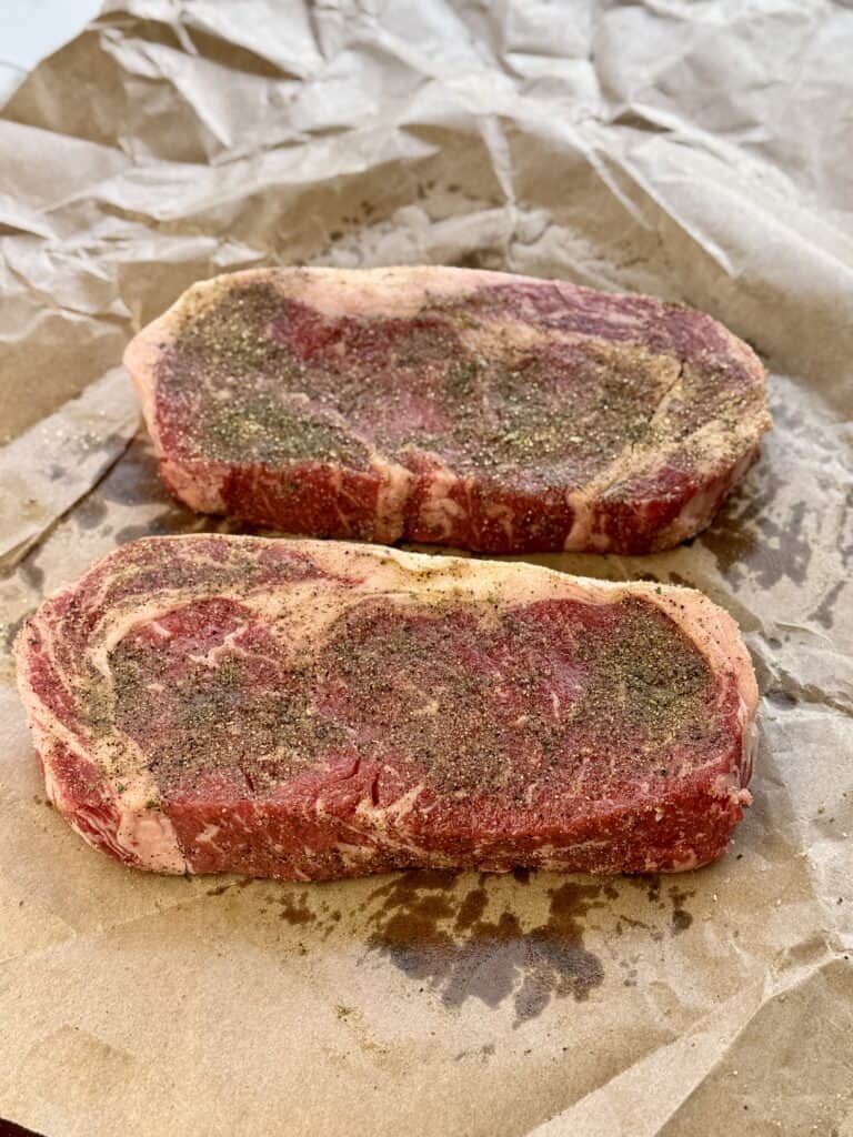 Steak being seasoned.