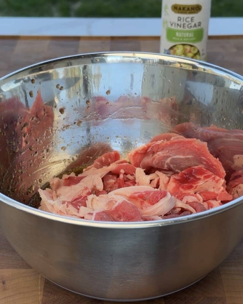 Shaved ribeye steak with marinade ingredients.