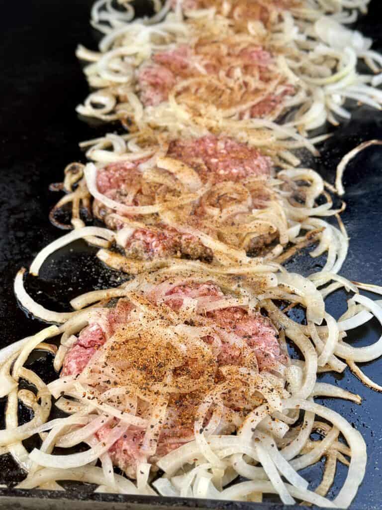Season burger and onions.