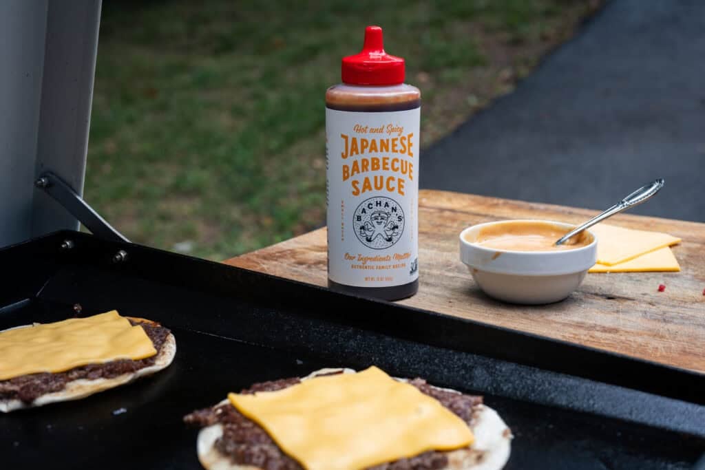 Cheese on burger on griddle.