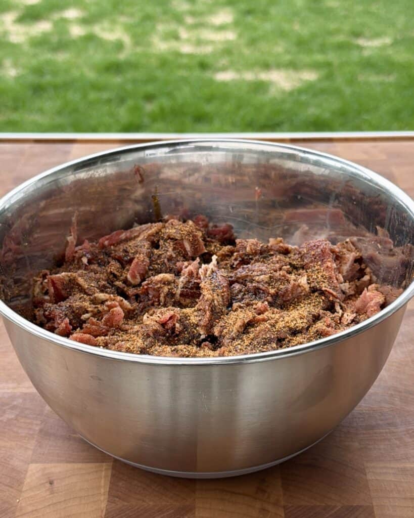 Shaved meat in mixing bowl.