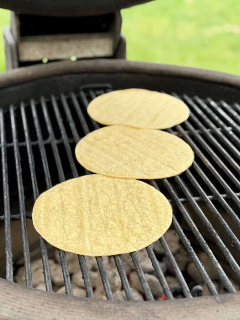Toast corn tortillas on grill.