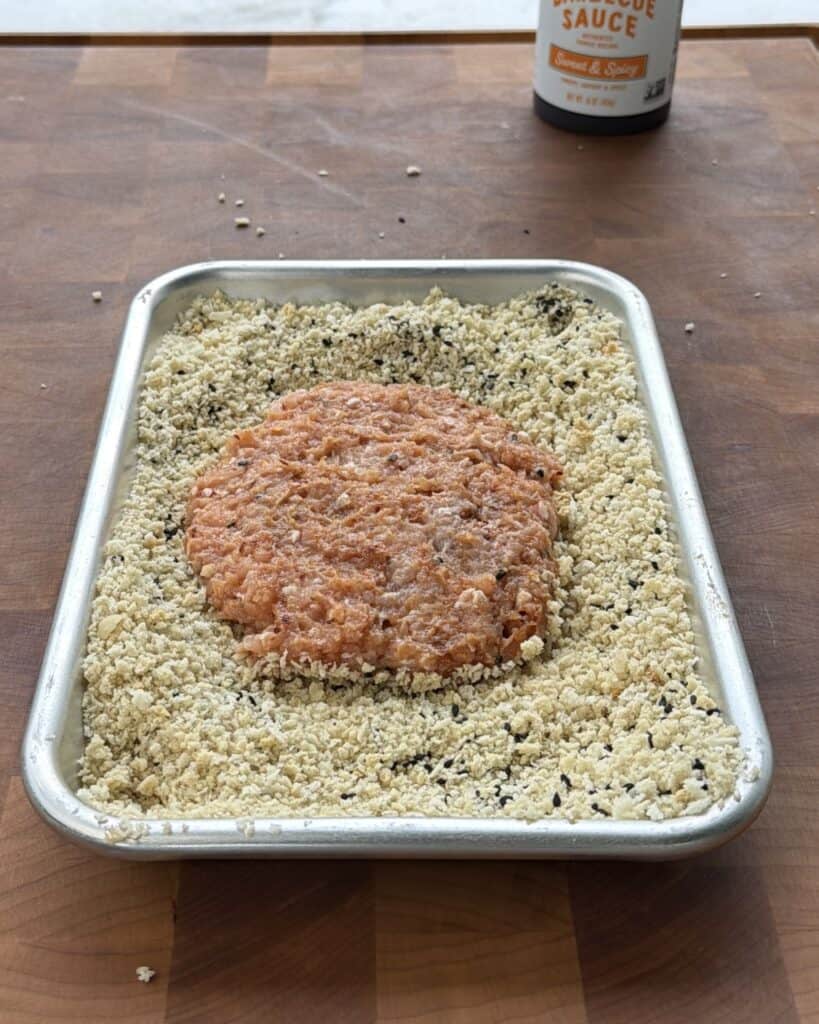 Pan with coating mixture and chicken patty.
