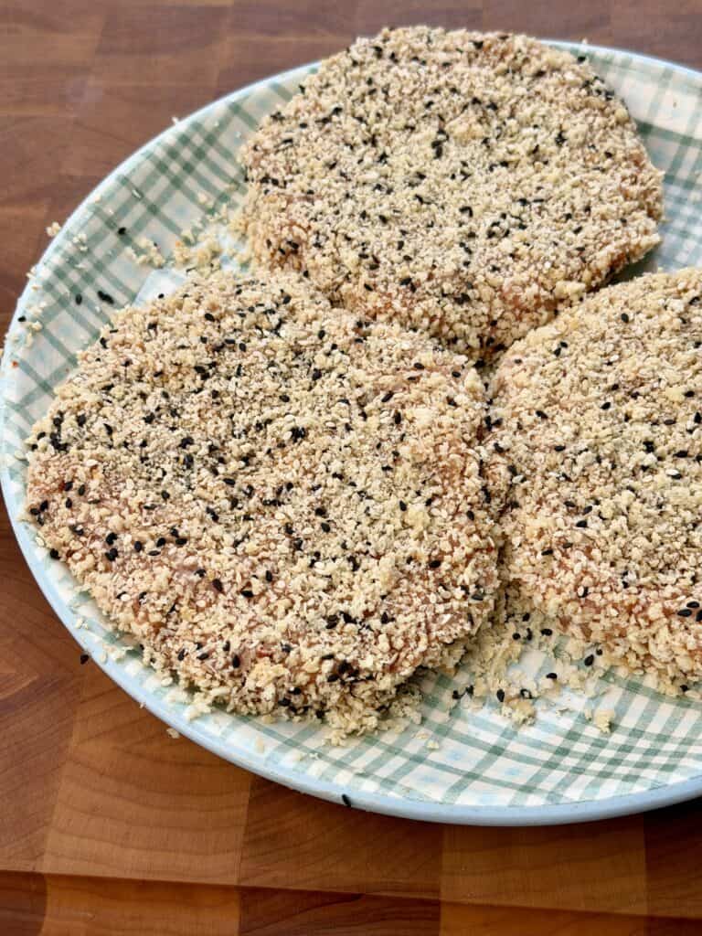Chicken Patties with coating mixture on plate.