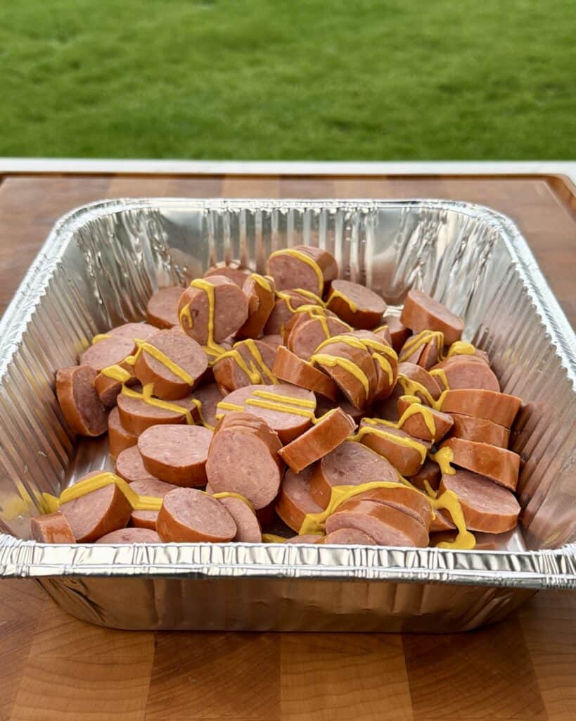 Yellow Mustard on Sausage in Pan.