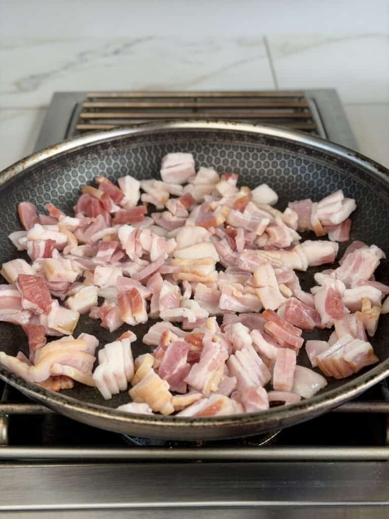 Cut Bacon in skillet.