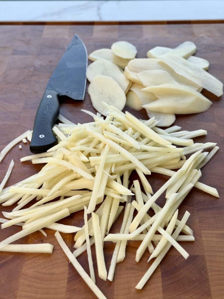 Sliced Raw Potatoes on Cutting Board..