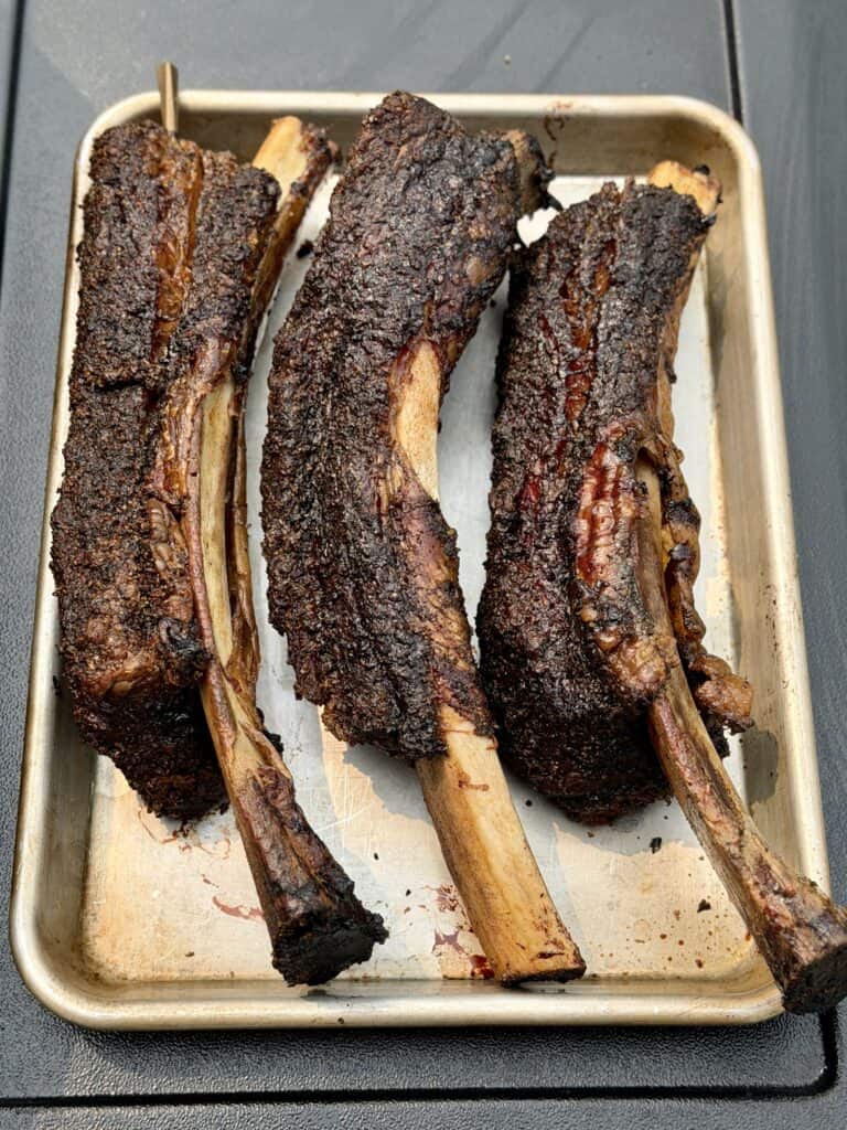 Three Cooked Beef Ribs on a pan.