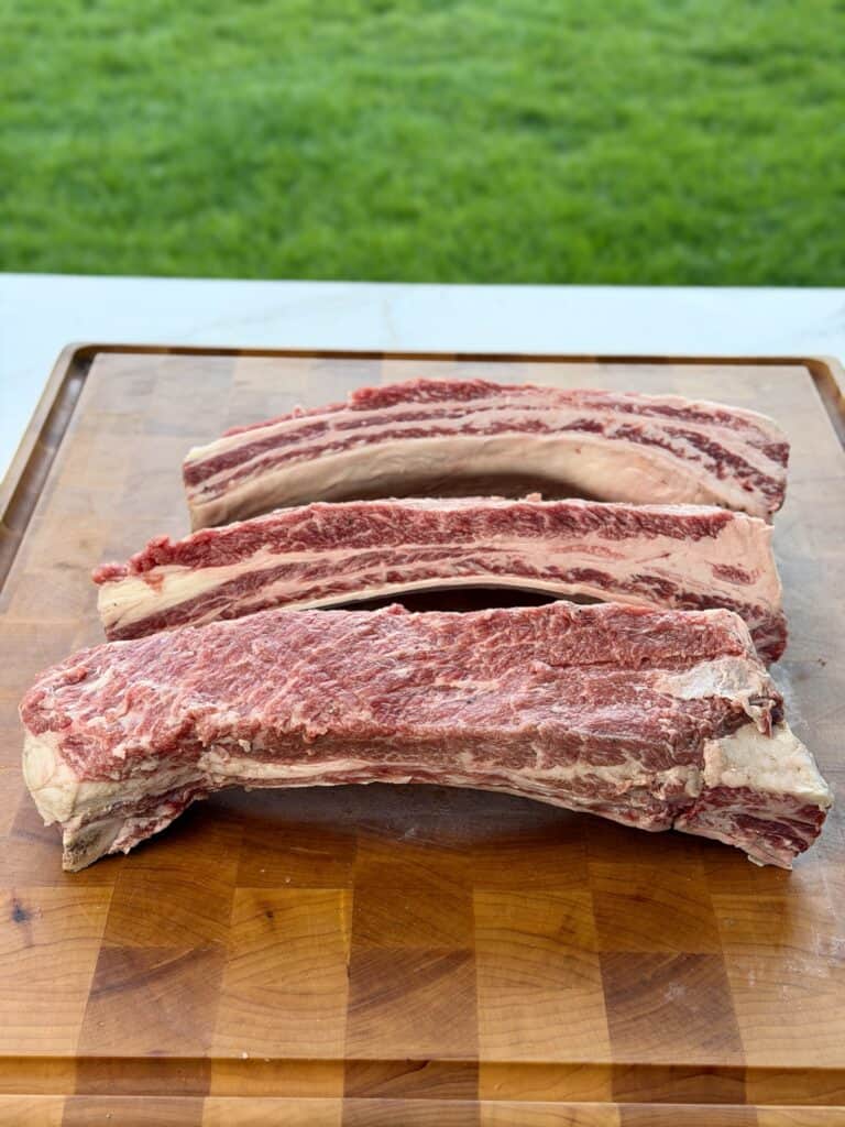 Smoked Beef Rib Sandwich Chimichurri Beef Ribs cut on cutting board.