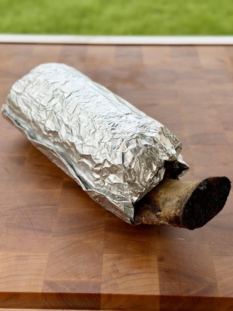 Beef Rib in Foil on Cutting Board.