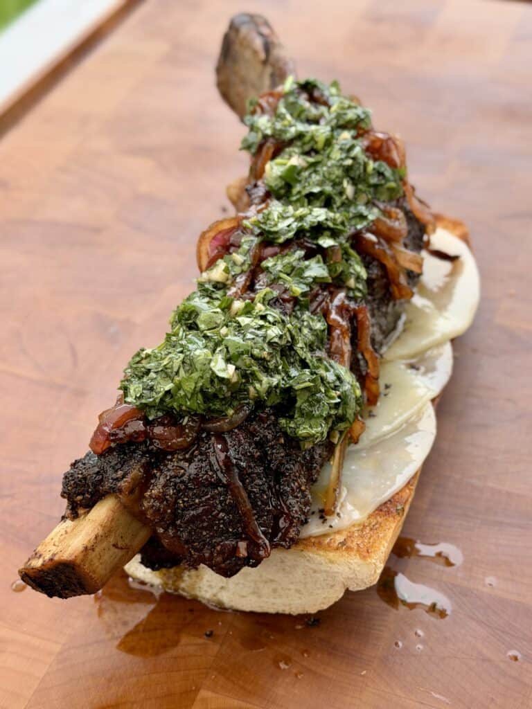 Beef Rib on Bun with Chimichurri Sauce on top.