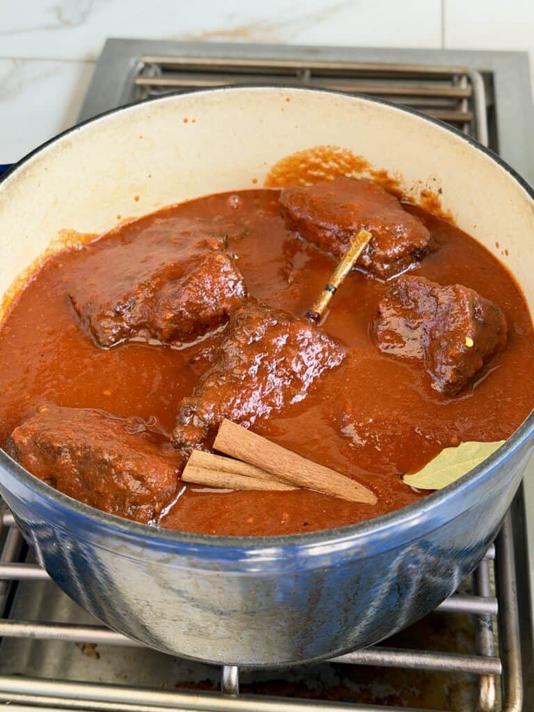 Birria Quesadilla Beef and Sauce in Dutch oven.
