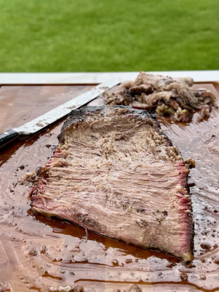 Meat on cutting board with knife.