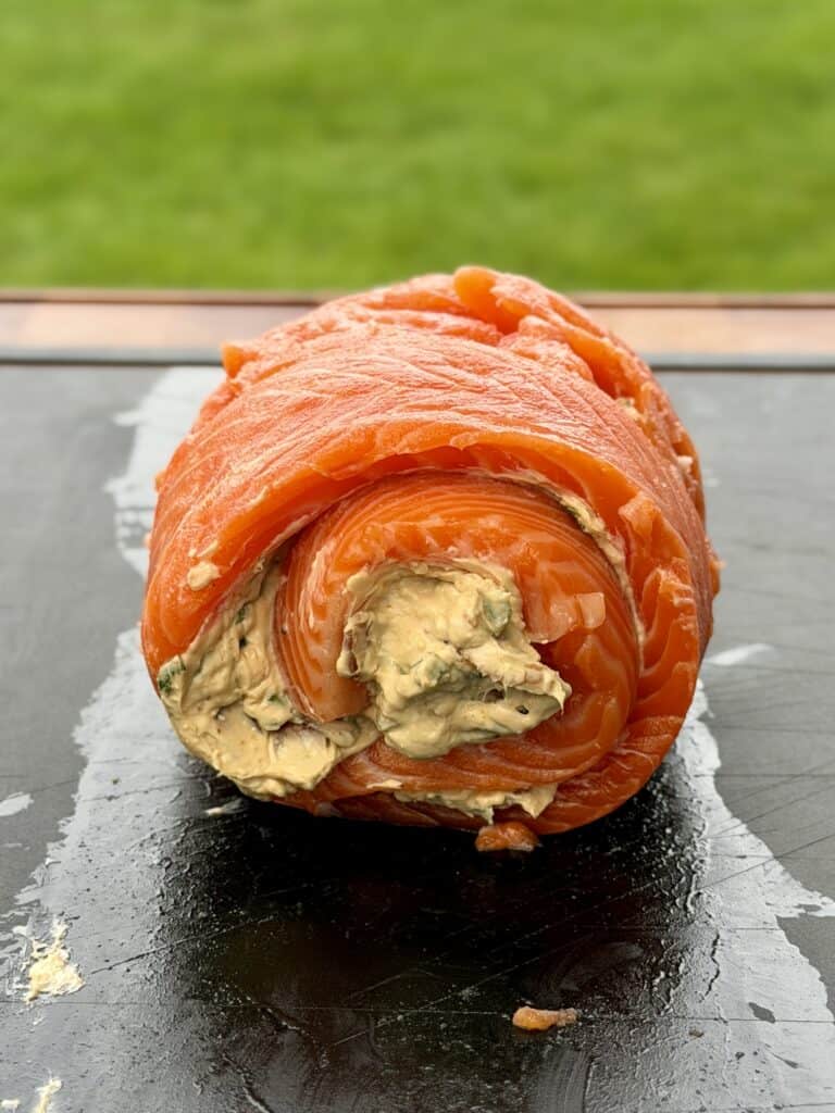 Rolled Chili Sesame Salmon Pinwheels on a cutting board.